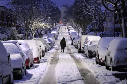 Getty Images A man walks up a snow-covered road