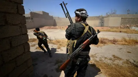 Reuters Members of the paramilitary Popular Mobilisation battle Islamic State militants inside Tal Afar, northern Iraq (23 August 2017)