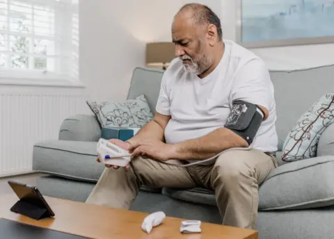Doccla Man using a blood pressure monitor at home