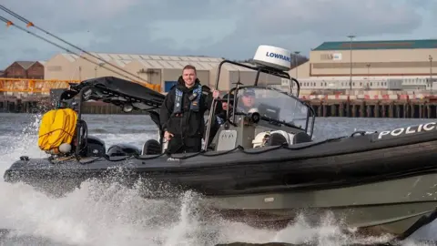 Northumbria Police Ryan Young aboard a police boat as he volunteers with Northumbria Police as a special constable