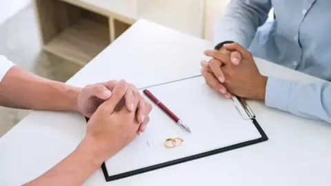 Getty Images An anonymous couple facing each other across a desk