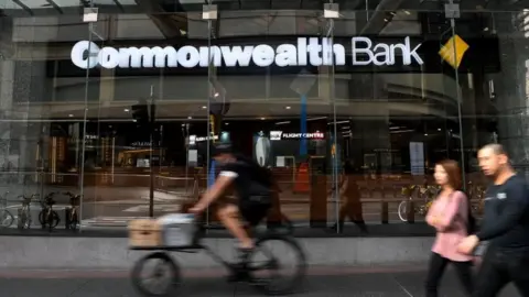 EPA Pedestrians walk past a Commonwealth Bank branch