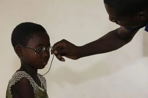 Getty Images A child tries on a new pair of glasses in Togo