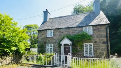 Angela Ramsell Angela's cottage in north Powys. The sun is shining and it's surrounded by greenery.