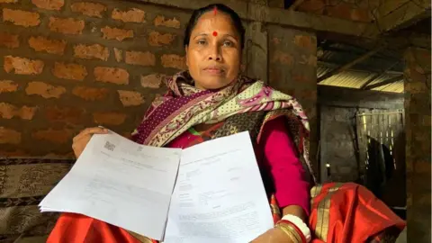 Dilip Kumar Sharma Sefali Rani Das holding up documents to prove her Indian citizenship