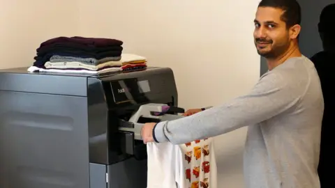 Foldimate A man uses Foldimate to automatically fold clothes