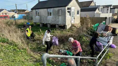  Bradley Thompson Litter pickers cleaning a grass area