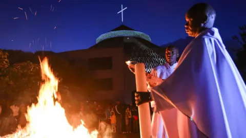 EPA Priests led the service in Nairobi next to a fire outside the church