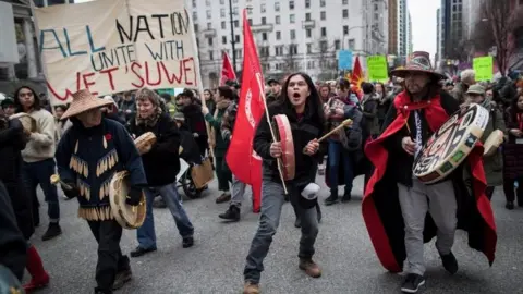 PA Alex Spence beats a drum and sings during a march in support of pipeline protesters in Vancouver