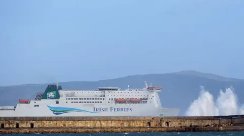 Strong winds cause the waves to hit the breakwater at Holyhead as the Irish Ferries ship Isle of Inishmore pulls into the harbour on the Island of Anglesey in Wales