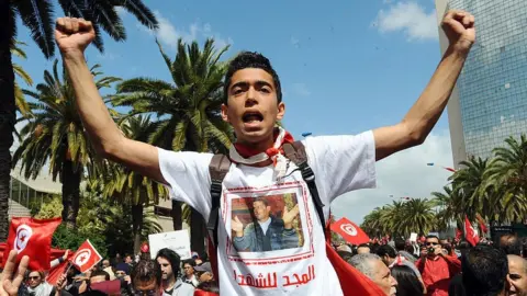 Getty Images A man wearing a tee-shirt with a portrait of Tunisian protest hero Mohamed Bouazizi shouts during a demonstration on April 9, 2012 in Tunis