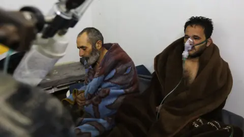 AFP Syrians reportedly suffering from breathing difficulties following a Syrian government air strikes on the town of Saraqeb rest at a field hospital (4 February 2018)