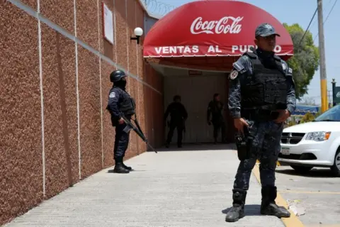 Reuters Police officers guard the entrance of the Coca-Cola FEMSA distribution plant after it closes down due to the issues of security and violence during the campaign rally of Independent presidential candidate Margarita Zavala (unseen) in Ciudad Altamirano in Guerrero state, Mexico April 3, 2018.