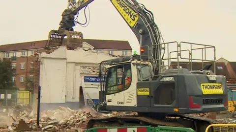 BBC A bulldozer demolishes a building at Darlington station