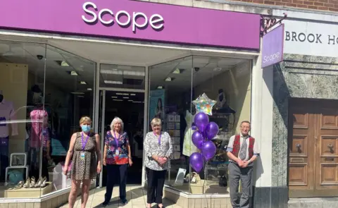 PA Media Peter Moss (right) with (left to right) fellow volunteers Angie Gould and Sue Thornton, and manager Lorraine Smith.