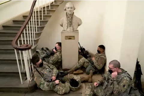 Getty Images Soldiers rest against statue of George Washington