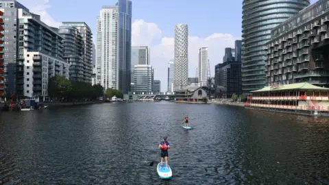 PA Media Paddleboarders off the Isle of Dogs, London, on Wednesday