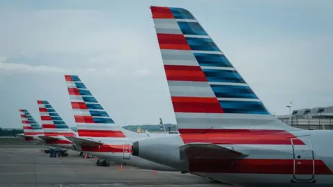 Getty Images Tails of American Airline planes are seen as the planes sit parked at gates at Reagan National Airport on Thursday, April 27, 2023