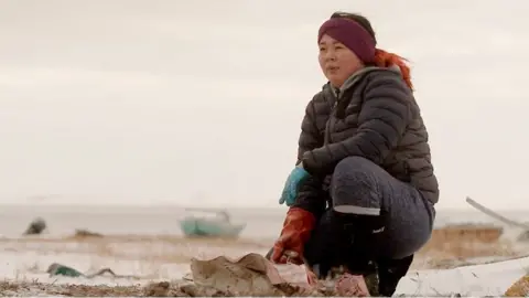 A local woman with a seal carcass in northern Alaska