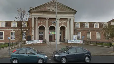 Google 1930s two-storey brick council building with four pillars at entrance