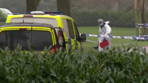 A forensic officer within the police cordon