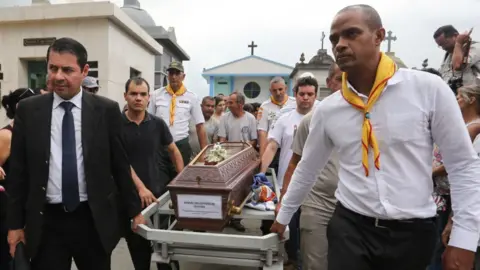 Getty Images Relatives and friends at the funeral of student Samuel Melquíades Oliveira Silva, 16, at the São Sebastião Cemetery in Suzano, Sao Paulo, on the afternoon of Thursday 14 March, 2019.