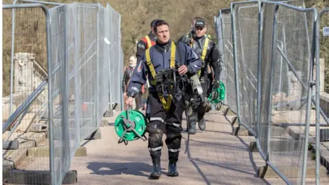 National Trust Police divers walk across the bridge