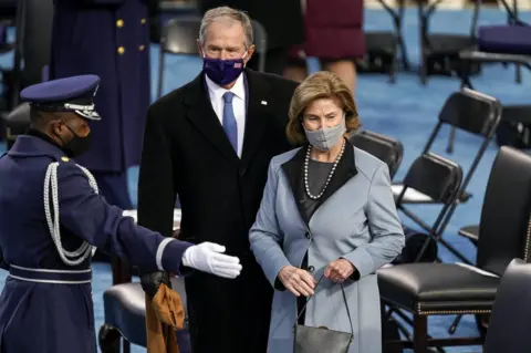 Kent Nishimura / Getty Images Former President George W. Bush and former First Lady Laura Bush are shown their seats