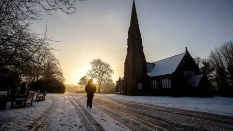 PA A person walks through Allerton Cemetery near Liverpool on Thursday