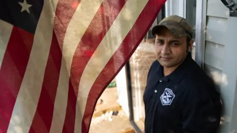 Dustin Duong for the BBC Zia Ghafoori stands in front of his home in North Carolina