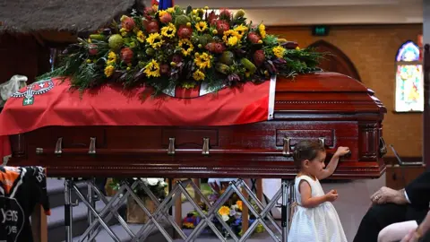 Getty Images The young daughter of Rural Fire Service volunteer Andrew O'Dwyer stands in front of her fathers casket