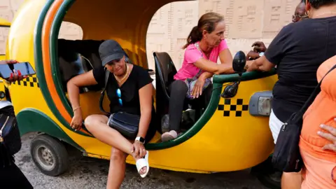 Taxi drivers wait in line to fill fuel at a petrol station in Havana, Cuba, on 25 April 2023