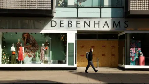 Reuters Man walking past a Debenhams store