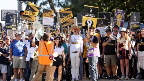 US actors holding picket signs and going on strike