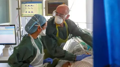 Getty Images Medical staff treating a Covid-19 patient at Frimley Park Hospital