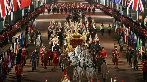 Reuters The Gold State Coach is ridden alongside members of the military during a full overnight dress rehearsal of the Coronation Ceremony of Britain’s King Charles and Camilla, Queen Consort in London,