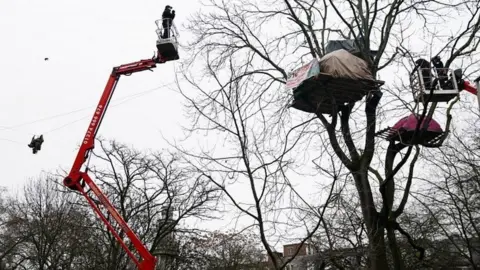 PA Media Enforcement officers using aerial platforms to try and coax HS2 protesters down from trees