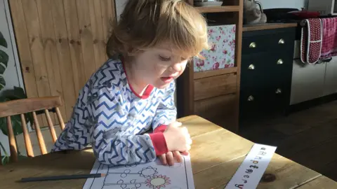 BBC A young boy colouring