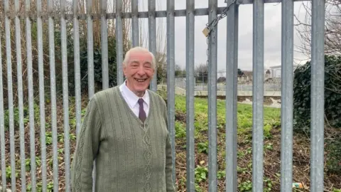 LUKE DEAL/ BBC Michael Read, in front of Broomhill Lido, wearing a green cardigan and a tie