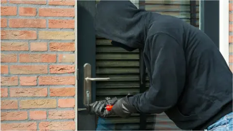 Getty Images Hooded man attempting break-in