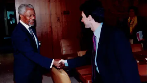 Kofi Annan shaking hands with Mark Devenport