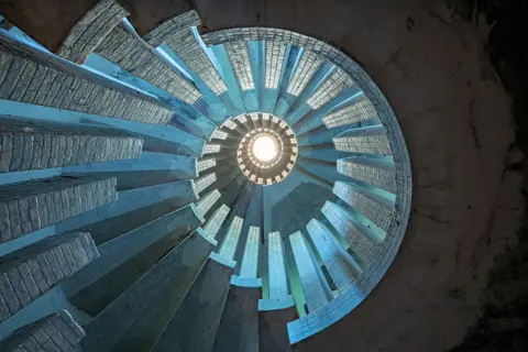 Gina Soden A view upward at a concrete staircase in an abandoned manor in Wimbledon, UK