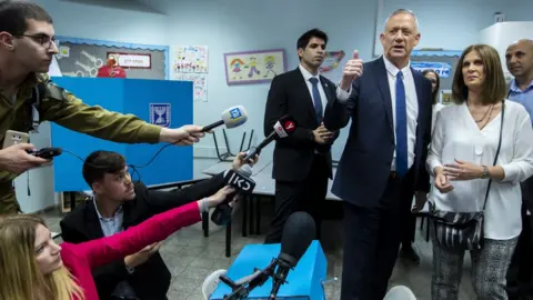 EPA Benny Gantz and his wife Revital cast the ballots in Rosh Haayin, near Tel Aviv (9 April 2019)