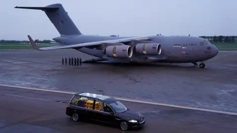 Reuters The hearse carrying the Queen's coffin drives away from the plane that flew it from Edinburgh to RAF Northolt