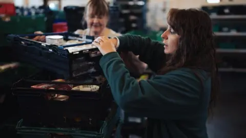 Bournemouth Foodbank A woman filling a container with food