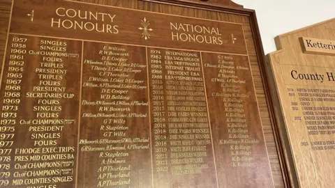 Ollie Conopo/BBC A wooden honours board, with lots of gold writing on it. 