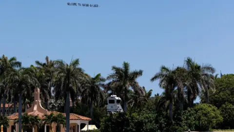 Reuters A plane flying a flat above Mar-a-Lago displaying writing reading 'Welcome to Qatar-a-Lago'