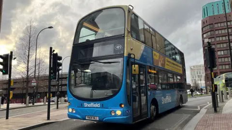 A blue and white double decker bus.