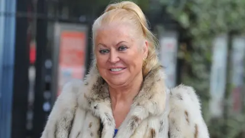 Getty Images Celebrity Big Brother contestant Kim Woodburn seen at the ITV Studios in 2017, wearing a furry cream and brown coat.