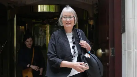 PA Media Harriet Harman is seen walking out of 10 Downing Street. She is wearing glasses with pale blue rims and has a bag over her shoulder